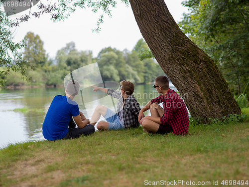 Image of men sitting on the bank of the river