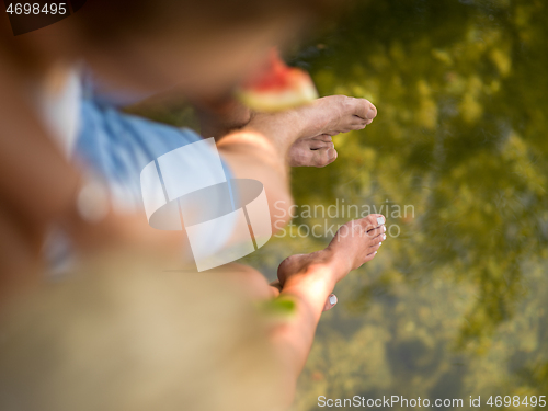 Image of Couple eating watermelon enjoying picnic time