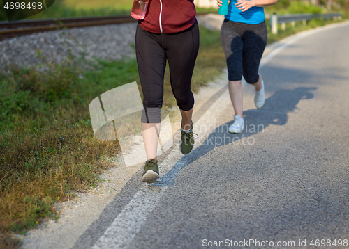 Image of women jogging along a country road
