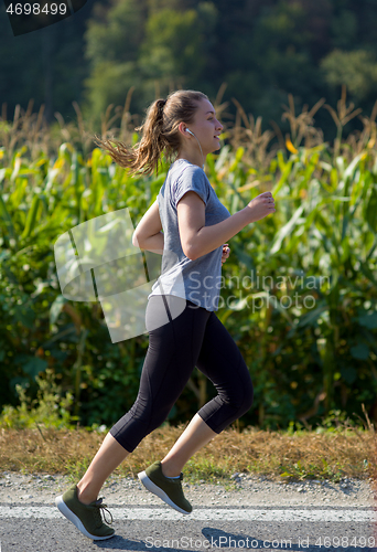 Image of woman jogging along a country road