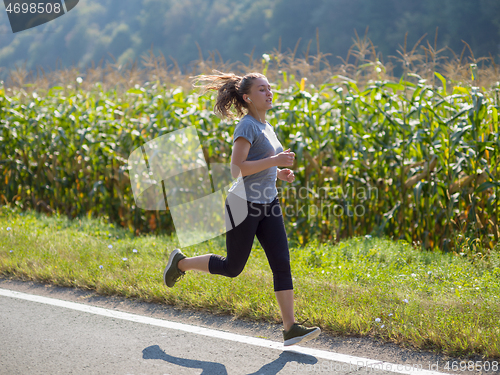 Image of woman jogging along a country road