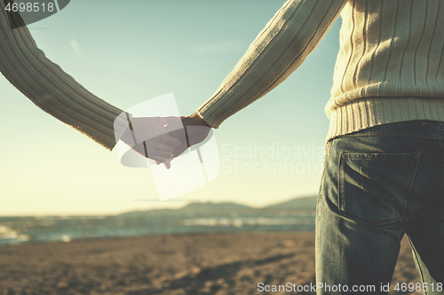 Image of Loving young couple on a beach at autumn sunny day