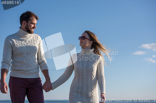 Image of Loving young couple on a beach at autumn sunny day