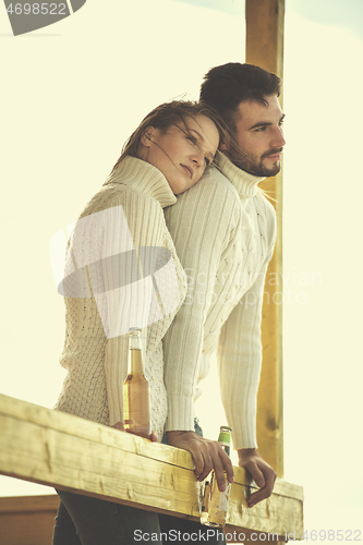 Image of young couple drinking beer together at the beach