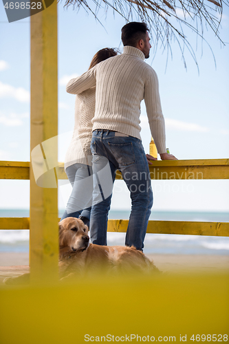 Image of young couple drinking beer together at the beach