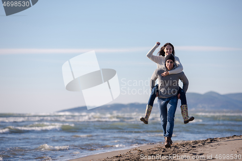 Image of couple having fun at beach during autumn