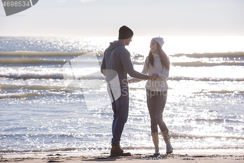 Image of Loving young couple on a beach at autumn sunny day