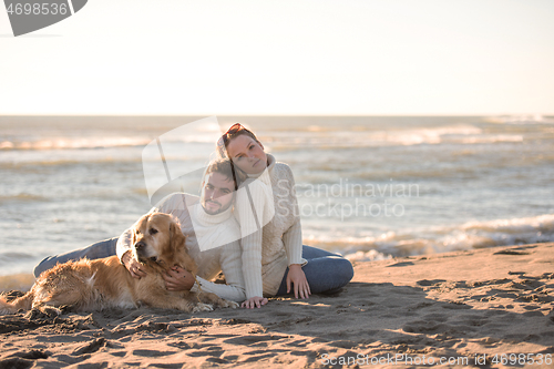 Image of Couple with dog enjoying time on beach