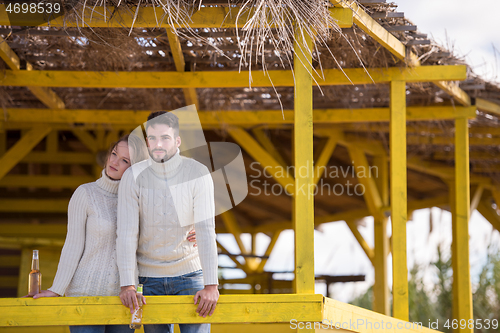 Image of young couple drinking beer together at the beach