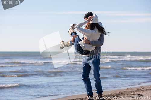 Image of Loving young couple on a beach at autumn sunny day