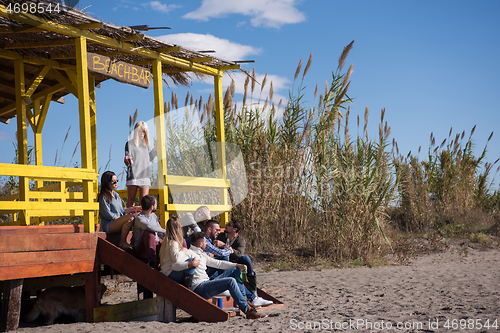 Image of Group of friends having fun on autumn day at beach