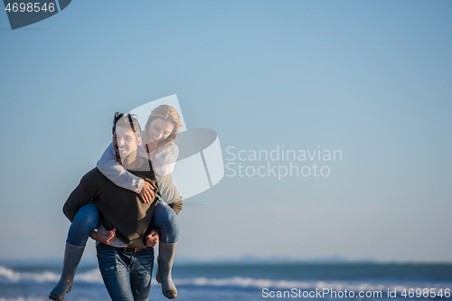 Image of couple having fun at beach during autumn