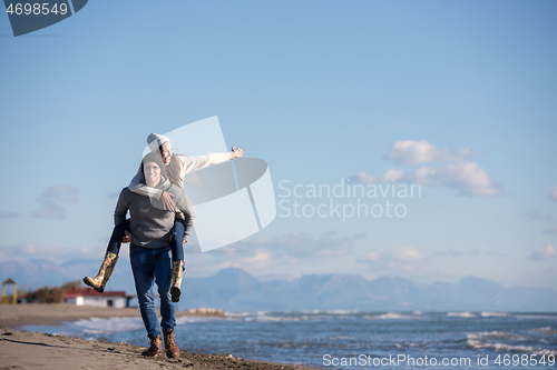 Image of couple having fun at beach during autumn