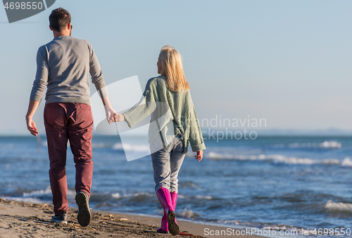 Image of Loving young couple on a beach at autumn sunny day