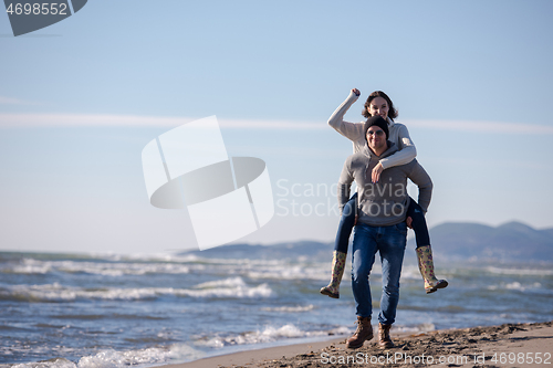 Image of couple having fun at beach during autumn