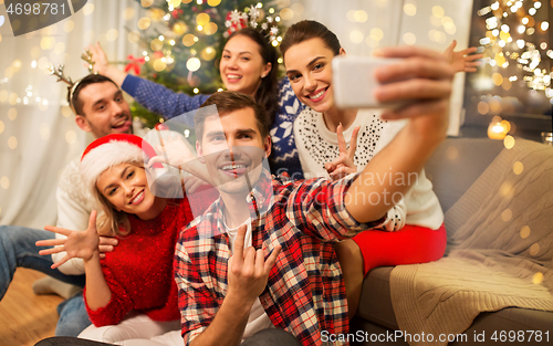 Image of friends celebrating christmas and taking selfie