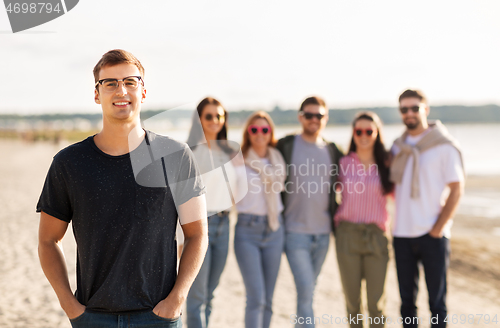 Image of happy man with friends on beach in summer