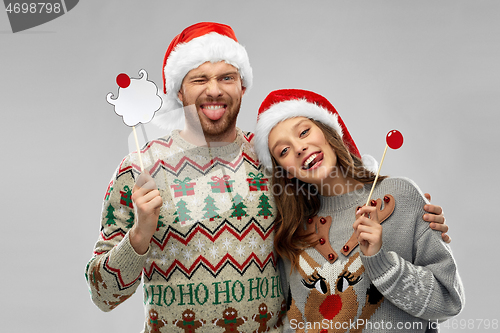 Image of couple with christmas party props in ugly sweaters