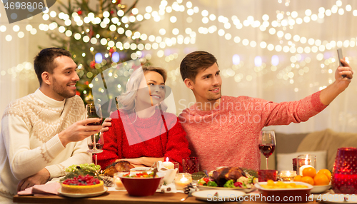 Image of friends taking selfie at christmas dinner