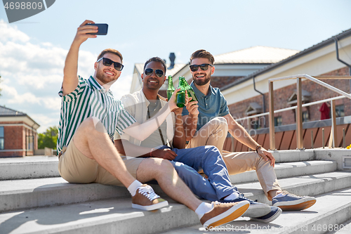 Image of men drinking beer and taking selfie by smartphone