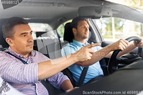 Image of car driving school instructor teaching male driver