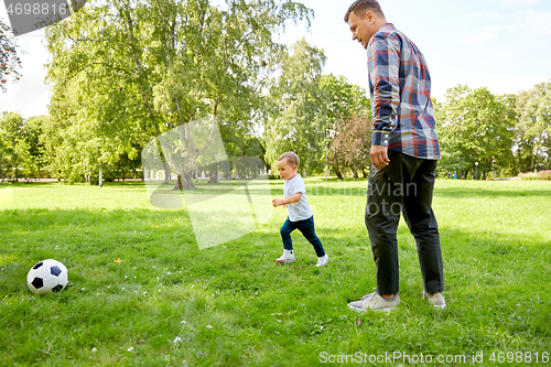 Image of father with little son playing soccer at park