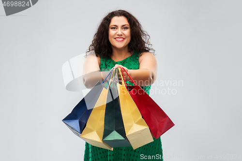 Image of happy woman in green dress with shopping bags