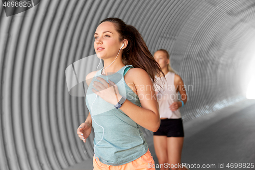 Image of women or female friends with earphones running