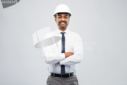 Image of smiling indian male architect in helmet over grey