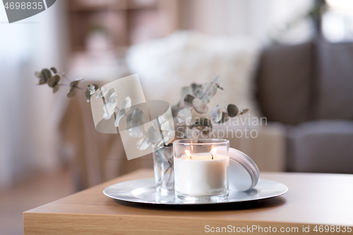 Image of burning fragrance candle on table at cozy home