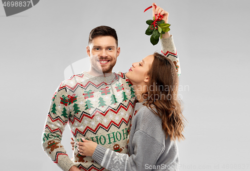 Image of happy couple kissing under the mistletoe