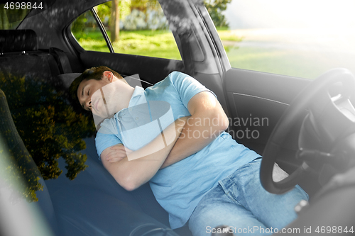 Image of tired man or driver sleeping in car