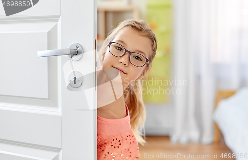 Image of beautiful girl l in glasses behind door at home