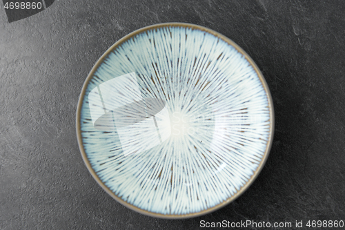 Image of close up of blue ceramic plate on slate background