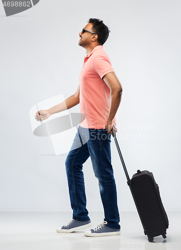 Image of smiling indian man in polo shirt with travel bag