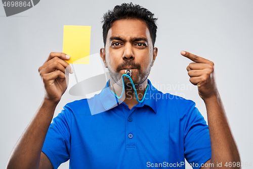 Image of indian referee whistling and showing yellow card