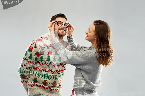 Image of happy couple at christmas ugly sweater party