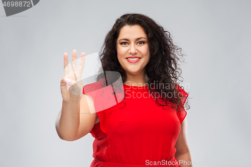 Image of happy woman in red dress showing three fingers