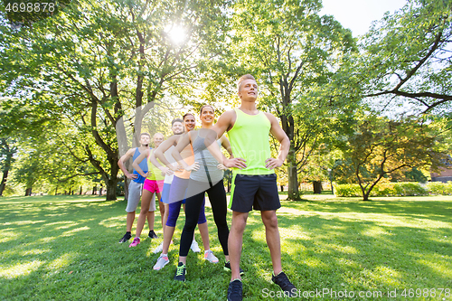 Image of group of happy friends or sportsmen at summer park