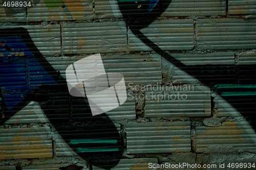 Image of Graffiti painted on striated bricks on a wall