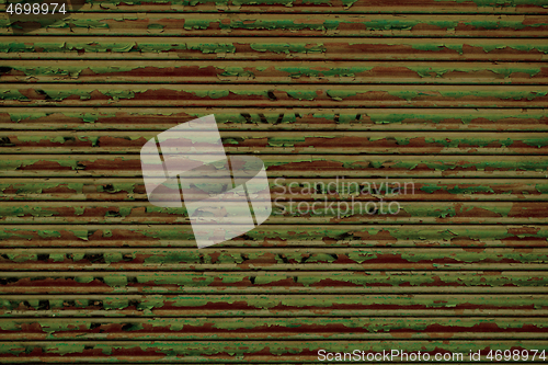 Image of Flaking peeling green paint on rusty metal panel