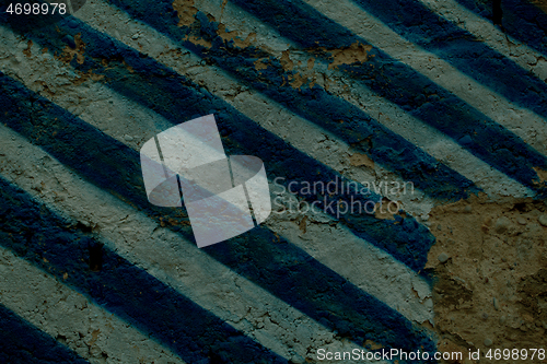 Image of Diagonal blue and white stripes on an old wall