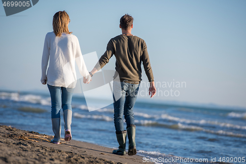 Image of Loving young couple on a beach at autumn sunny day