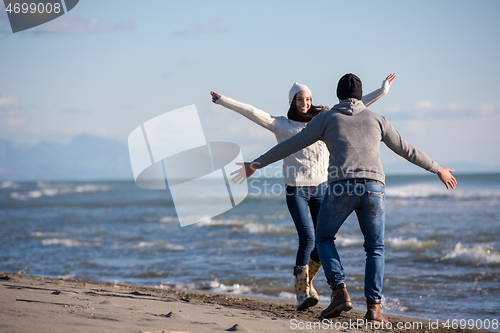 Image of Loving young couple on a beach at autumn sunny day