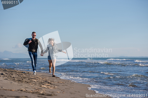 Image of Loving young couple on a beach at autumn sunny day