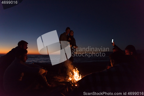 Image of Friends having fun at beach on autumn day