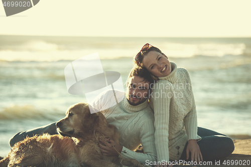 Image of Couple with dog enjoying time on beach