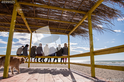 Image of Group of friends having fun on autumn day at beach