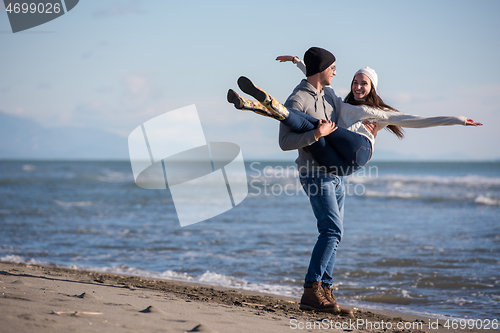 Image of Loving young couple on a beach at autumn sunny day