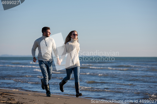 Image of Loving young couple on a beach at autumn sunny day